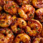 Crispy golden prawns fry garnished with herbs.