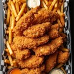 “Crispy chicken strips served with French fries and dipping sauces in a Bangalore restaurant”