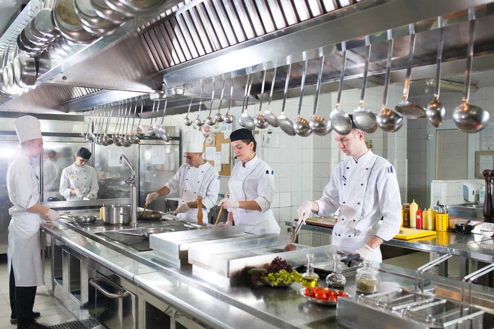 Chefs working together in a large commercial kitchen.