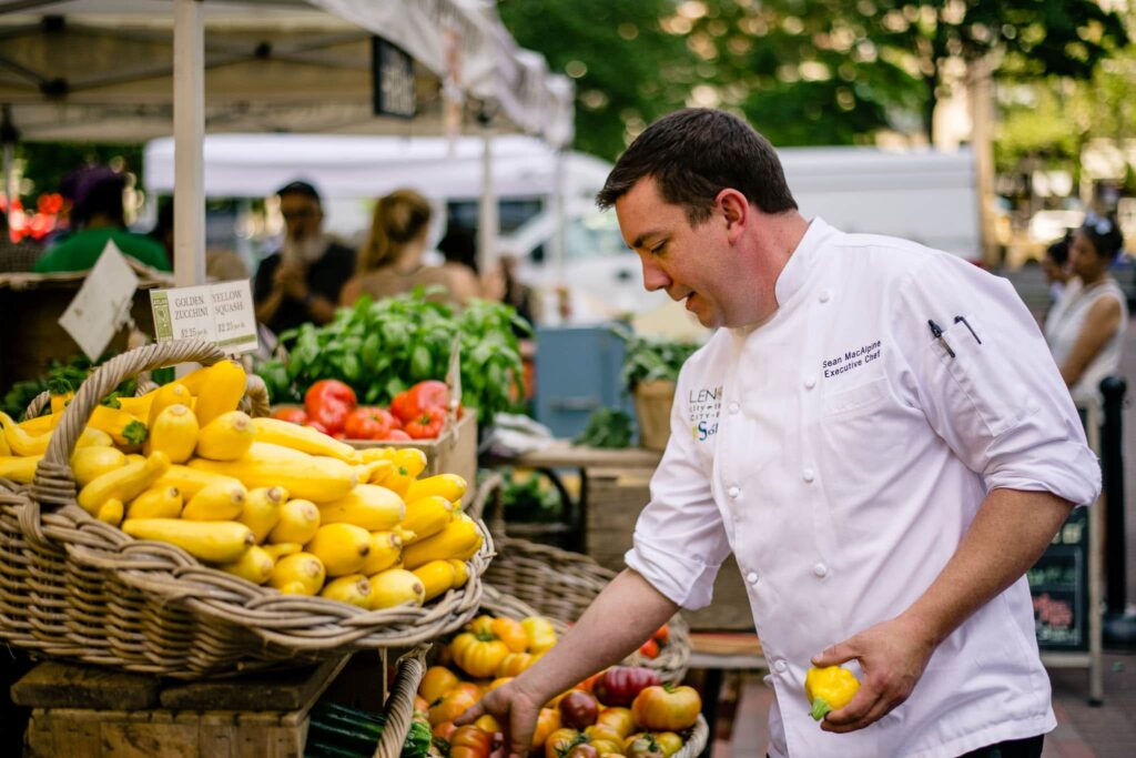 Chef selecting fresh farm produce from trusted suppliers to ensure the highest ingredient quality at the restaurant.