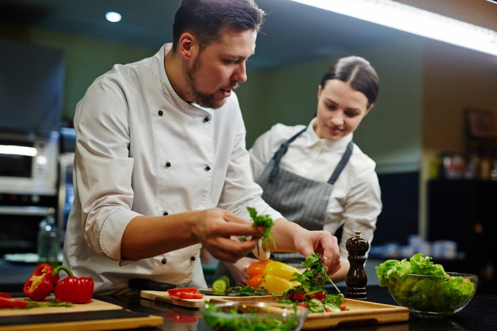 Chef preparing a fresh dish on the stove in a restaurant kitchen as part of daily cooking practices with no reheating or reuse